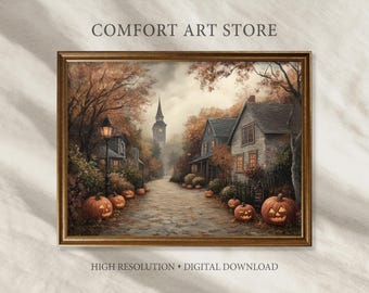 Puede incluir: Una impresión digital enmarcada que representa una escena de pueblo otoñal. La obra de arte muestra una calle adoquinada con casas, árboles y calabazas talladas. El texto "COMFORT ART STORE" y "HIGH RESOLUTION • DIGITAL DOWNLOAD" son visibles.