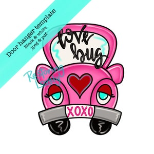 以下が含まれることがあります： 「love bug」と「XOXO」が書かれたピンクの車の形のドアハンガー。車はまつげと赤いハートを付けています。