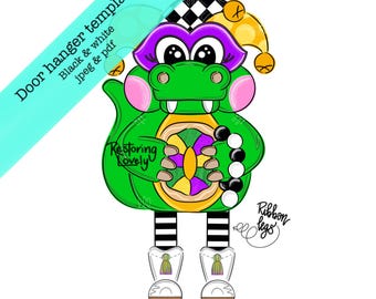 Op de afbeelding: Een grillige groene alligator deurhanger sjabloon met een narrenhoed, met een kleurrijk wiel. Het ontwerp omvat roze wangen, zwart-wit gestreepte benen en de tekst "Door hanger template Black & white jpeg & pdf".