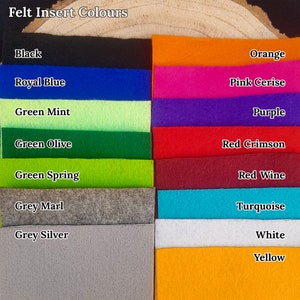Pu&ograve; includere: Esposizione di campioni di tessuto in feltro in vari colori, tra cui nero, blu reale, verde menta, arancione, rosa cerise e giallo. Il testo "Felt Insert Colours" &egrave; visibile.