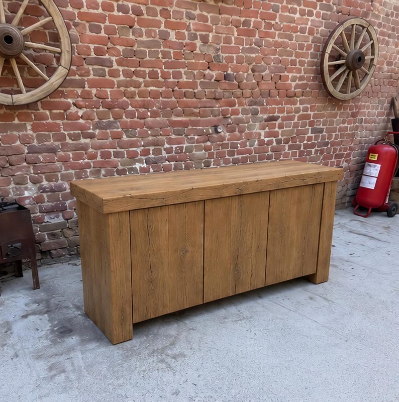 Peut inclure: Un buffet rectangulaire en bois avec une finition brun clair naturelle et des motifs de grain de bois visibles. Ce meuble pr&eacute;sente une surface sup&eacute;rieure &eacute;paisse et trois portes de placard verticales au design plat et lisse.