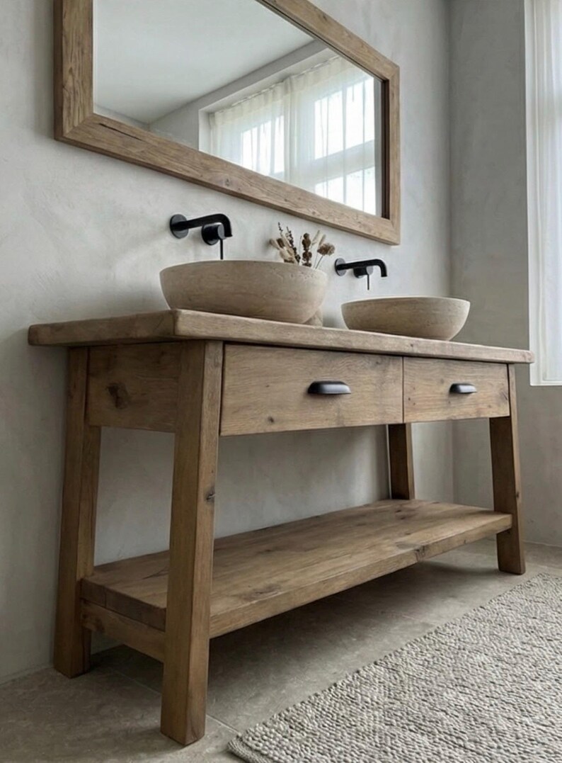 May include: A rustic wooden bathroom vanity with two integrated bowl sinks and black faucets. The vanity features two drawers and a lower shelf, all made of light brown wood. A large wooden-framed mirror hangs above the vanity.