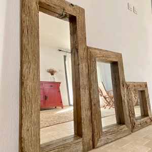 Puede incluir: Tres espejos de diferentes tama&ntilde;os con marcos de madera r&uacute;stica, con el espejo m&aacute;s grande en primer plano. Los espejos est&aacute;n hechos de madera recuperada con un acabado de madera natural. Los espejos est&aacute;n colgados en una pared blanca.