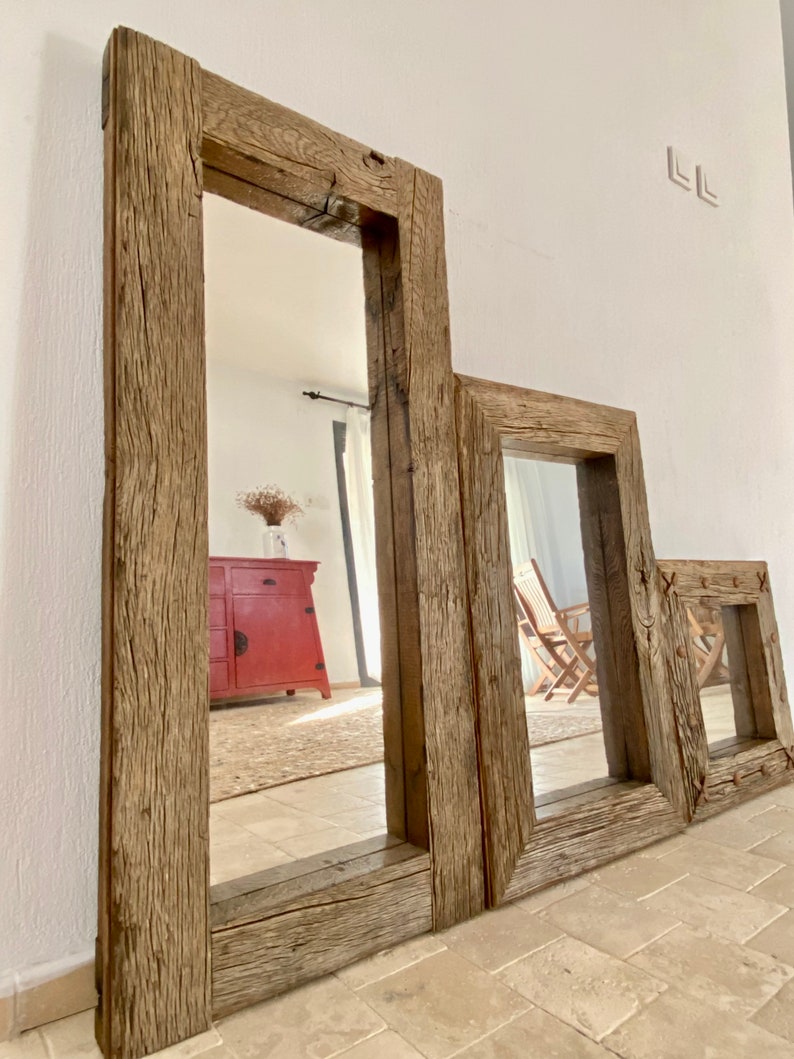 Puede incluir: Tres espejos de diferentes tama&ntilde;os con marcos de madera r&uacute;stica, con el espejo m&aacute;s grande en primer plano. Los espejos est&aacute;n hechos de madera recuperada con un acabado de madera natural. Los espejos est&aacute;n colgados en una pared blanca.