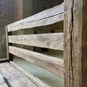 Pu&ograve; includere: Una panca in legno rustica con schienale a doghe e una seduta larga. La panca &egrave; realizzata in legno invecchiato con una finitura naturale.