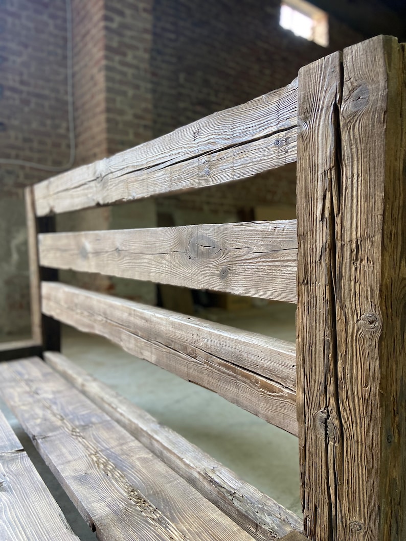 Pu&ograve; includere: Una panca in legno rustica con schienale a doghe e una seduta larga. La panca &egrave; realizzata in legno invecchiato con una finitura naturale.