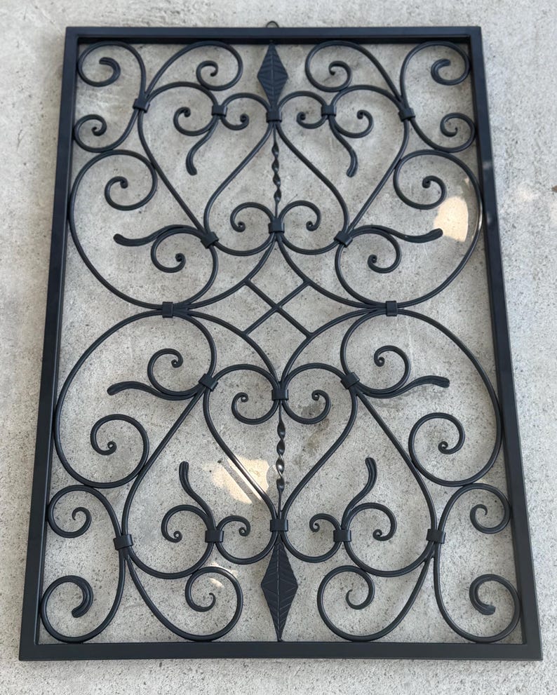 Puede incluir: Decoraci&oacute;n de pared de metal negro con un dise&ntilde;o de desplazamiento decorativo. El dise&ntilde;o presenta un patr&oacute;n repetitivo de corazones y remolinos.