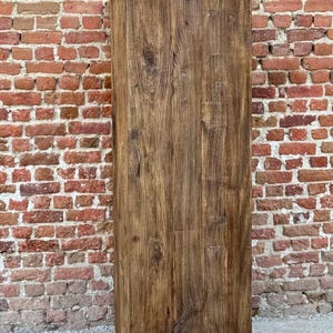 Pode incluir: Um arm&aacute;rio de madeira alto com uma &uacute;nica porta. O arm&aacute;rio &eacute; feito de madeira marrom escura com um acabamento r&uacute;stico. A porta est&aacute; fechada e tem um design simples.