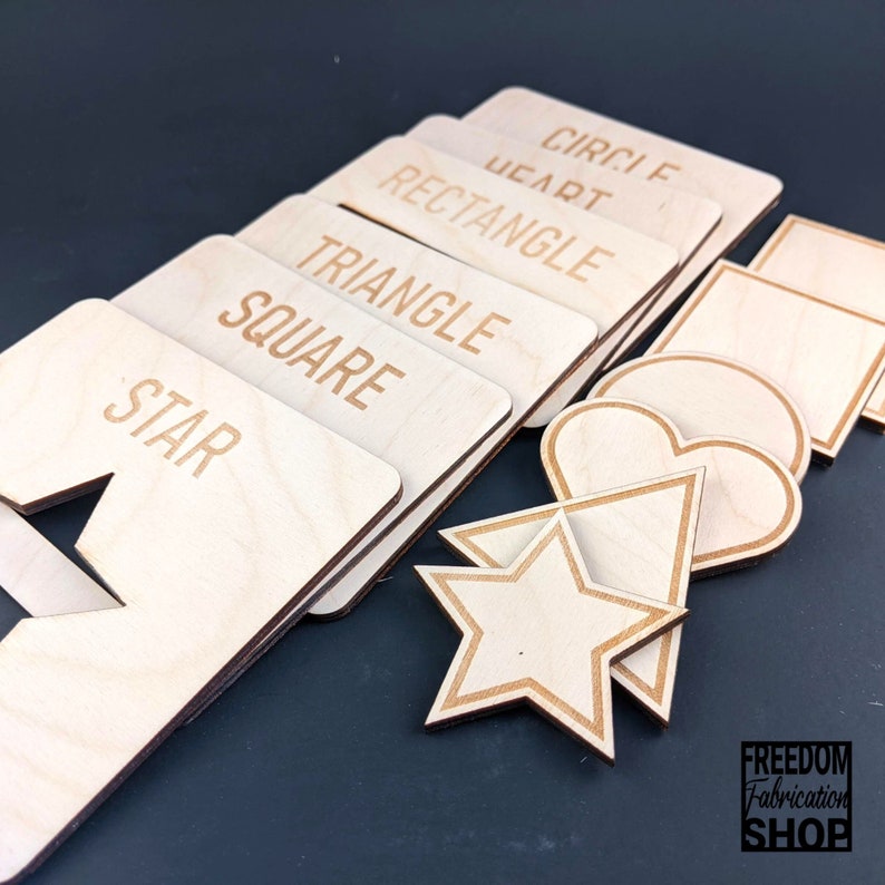 May include: Wooden shapes with labels for circle, heart, rectangle, triangle, square, and star. The shapes are cut out of wood and have a natural finish.