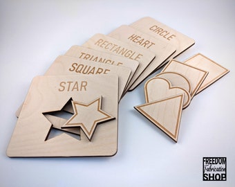 May include: Wooden puzzle pieces with different shapes, including a circle, heart, rectangle, triangle, square, and star. Each piece has the name of the shape written on it.