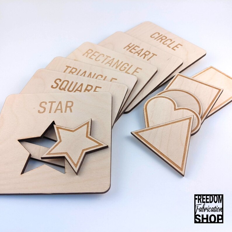 May include: Wooden puzzle pieces with cutouts of different shapes, including a star, circle, heart, square, rectangle, and triangle. Each piece has the name of the shape written on it.