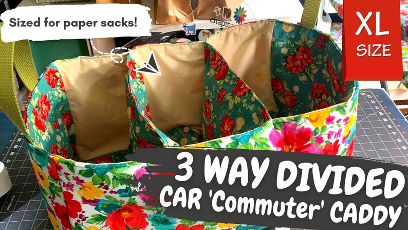 May include: A floral fabric car caddy with three divided compartments. The caddy has a green handle and is labeled "3 WAY DIVIDED CAR 'Commuter' CADDY" and "XL SIZE".