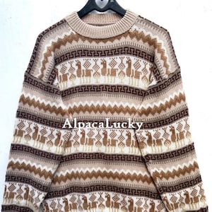 May include: A beige alpaca wool jumper with a brown, white and beige geometric pattern featuring llamas. The jumper has a crew neck and long sleeves.