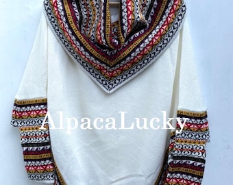 Può includere: Maglione bianco in lana di alpaca con un motivo geometrico colorato attorno al collo e alle maniche. Il maglione ha un collo alto e una vestibilità ampia.