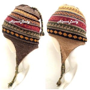 May include: Two brown and tan alpaca wool knit hats with ear flaps and a long tassel. The hats have a colorful geometric pattern and the text "Alpaca Lucky" is embroidered on each hat.