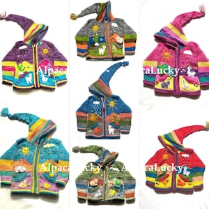 May include: A selection of brightly coloured, hand-knitted children's jackets. Each jacket has a long, pointed hood and a zip. The jackets are decorated with embroidered scenes of animals, suns, and landscapes. The text "Alpaca" and "caLucky" are visible.