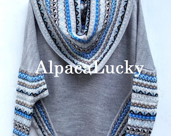 Può includere: Un maglione di alpaca grigio con collo a lupetto e motivi geometrici blu e marroni. Il maglione ha una vestibilità ampia ed è perfetto per essere indossato a strati.