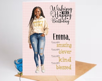 May include: A pink and white grid background with a black and gold birthday card. The card features a cartoon illustration of a young woman with brown skin wearing a white hoodie with the words "Happy Cake" in black text. The card says "Wishing you a Happy Birthday" in gold text and "Emma, You are amazing, You are clever, You are kind, You are blessed" in gold text.