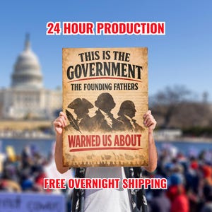 May include: A sign with the text "THIS IS THE GOVERNMENT THE FOUNDING FATHERS WARNED US ABOUT" in black and red. The sign features silhouettes of three figures and the words "24 HOUR PRODUCTION" and "FREE OVERNIGHT SHIPPING".