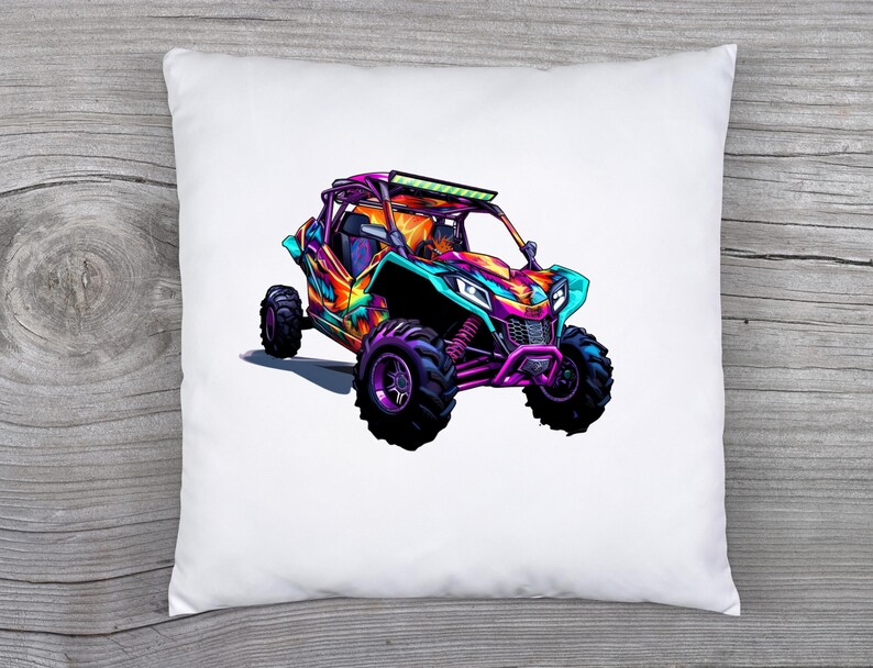 May include: A white pillow with a colorful illustration of a side-by-side off-road vehicle. The vehicle is painted in shades of pink, purple, blue, and green. It has a roll cage and a light bar on the roof.