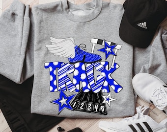 May include: A gray sweatshirt with a blue and white graphic that says "TRACK". The graphic includes a winged running shoe, stars, and hurdles. A black Adidas cap and white sneakers are also in the image.