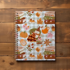 K&ouml;nnte beinhalten: Spiralgebundenes Notizbuch mit einem herbstlichen Muster. Das Design zeigt K&uuml;rbisse, Bl&auml;tter, B&uuml;cher und eine Figur mit Hexenhut. Das Notizbuch hat eine goldene Spiralbindung und einen hellgr&uuml;nen und wei&szlig;en karierten Hintergrund. Ca. 21 cm lang.