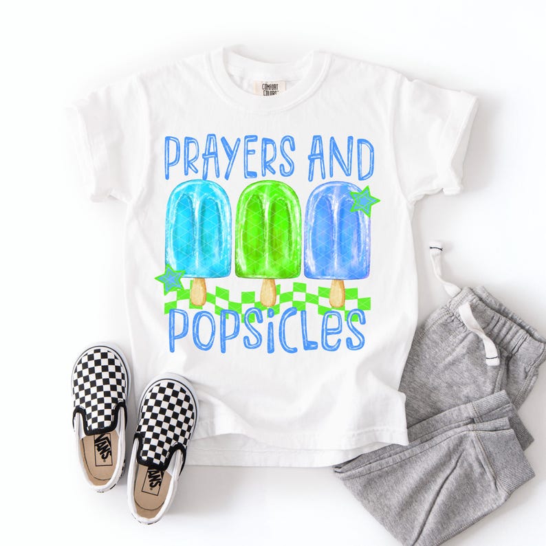 Puede incluir: Camiseta blanca con el texto azul "Prayers and Popsicles". La camiseta presenta un gr&aacute;fico de tres paletas de colores: azul, verde y azul. Un par de zapatos sin cordones a cuadros blancos y negros y un pantal&oacute;n de ch&aacute;ndal gris tambi&eacute;n est&aacute;n en la imagen.