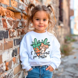 May include: A white sweatshirt with a green and orange carrot design and the text "I carrot wait for Easter".