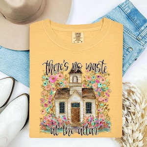 May include: A white ceramic mug with a black handle and the text "But First, Coffee" in a black, bold font. The mug is on a white surface. The mug is likely for hot beverages.