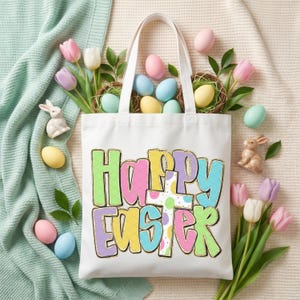 May include: A white tote bag with the words "Happy Easter" in colorful, outlined letters. The bag is surrounded by pastel-colored Easter eggs, nests, tulips, and ceramic bunnies, creating a festive spring scene.