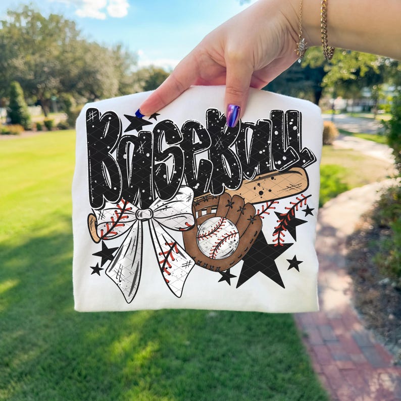 K&ouml;nnte beinhalten: Wei&szlig;es T-Shirt mit Baseball-Design. Das Design zeigt das Wort "Baseball" in schwarzer Graffiti-Schrift, einen Baseballschl&auml;ger, einen Baseballhandschuh, einen Baseball, eine Schleife und schwarze Sterne.