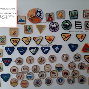 Peut inclure: Une collection d'insignes et de patchs de Girl Scouts vintage. Les insignes sont de formes, de tailles et de couleurs variées et présentent une variété de motifs, notamment des animaux, des scènes de nature et des activités. Le texte "JEXISLAND.ETSY.COM" apparaît sur plusieurs des insignes.