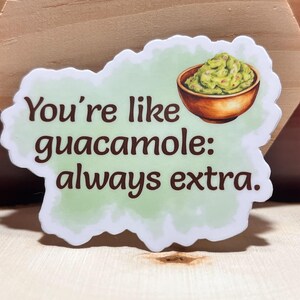 Könnte beinhalten: Ein grüner und weißer Aufkleber mit dem Text "You're like guacamole: always extra."