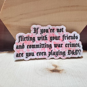 Puede incluir: Una pegatina rosa y blanca con texto negro que dice "Si no estás coqueteando con tus amigos y cometiendo crímenes de guerra, ¿estás jugando a D&D?"