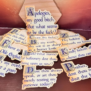 May include: A set of colourful stickers with humorous phrases written in an old English font. The stickers feature phrases like "Apologies, my good bitch" and "Dost thou always speak, or art thou merely testing my patience today?"