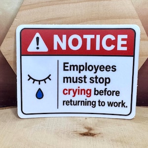 May include: A rectangular sticker with a white background and a red header containing the word NOTICE in white text next to an exclamation point. It features a closed eye with a blue teardrop and the text Employees must stop crying before returning to work.