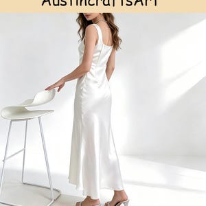 May include: A floor-length white satin dress with a square neckline and thick shoulder straps. The garment features a smooth, reflective finish and a flowing skirt that reaches the ankles. The text AustincraftsArt is visible at the top.