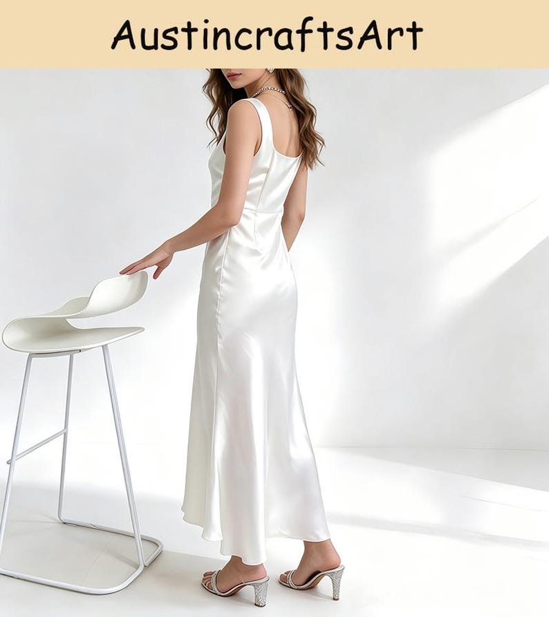 May include: A floor-length white satin dress with a square neckline and thick shoulder straps. The garment features a smooth, reflective finish and a flowing skirt that reaches the ankles. The text AustincraftsArt is visible at the top.