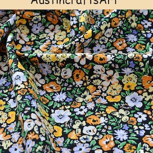 K&ouml;nnte beinhalten: Stoff mit einem dichten Blumenmuster aus orangefarbenen, gelben, wei&szlig;en und hellvioletten Bl&uuml;ten auf schwarzem Grund. Der Text AustincraftsArt ist oben sichtbar und die Nummer #1 ist in der unteren rechten Ecke des Bildes aufgedruckt.