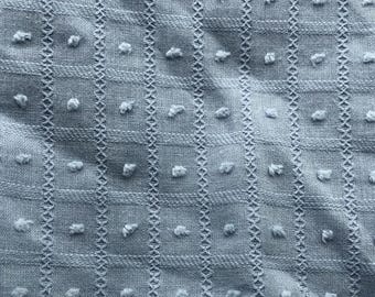 May include: Close-up of a textured, light blue fabric with a dotted pattern and vertical stitched lines. The text "AustincraftsArt" is displayed at the top. This fabric is suitable for various craft projects.