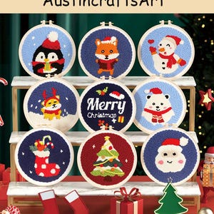 May include: Nine Christmas-themed embroidery hoops, each with a different design. Designs include a penguin, fox, snowman, dog, polar bear, Santa, Christmas tree, and a stocking. The text "Merry Christmas" is also featured.