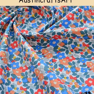 K&ouml;nnte beinhalten: Ein Stoff mit einem dichten Blumenmuster aus roten, blauen und orangefarbenen Bl&uuml;ten, gr&uuml;nen Bl&auml;ttern und kleinen Beeren auf wei&szlig;em Grund. Der Text Austin crafts Art steht oben und die Zahl 12 befindet sich in der unteren rechten Ecke.