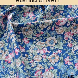 K&ouml;nnte beinhalten: Ein blauer Stoff mit einem dichten Blumenmuster aus rosa, wei&szlig;en und hellblauen Bl&uuml;ten sowie gr&uuml;nen Bl&auml;ttern. Der Text Austin crafts Art ist oben sichtbar und die Zahl 5 ist in der unteren rechten Ecke des Bildes aufgedruckt.