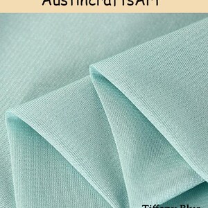 Może przedstawiać: Kawałek materiału w jednolitym kolorze Tiffany blue o drobno prążkowanej strukturze dzianiny. Materiał jest złożony, tworząc miękkie, warstwowe fałdy. Tekst AustincraftsArt jest widoczny u g&oacute;ry, a tekst Tiffany Blue znajduje się na dole.