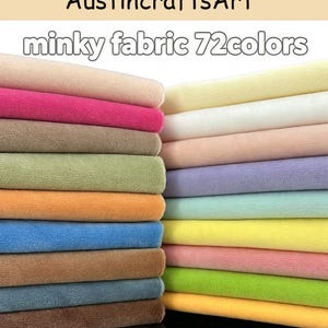 Może przedstawiać: Kolekcja złożonych próbek tkaniny minky w 72 kolorach, ułożonych w dwie kolumny. Na górze widoczny jest tekst Austin crafts Art oraz minky fabric 72colors. Tkanina ma miękką, pluszową fakturę i występuje w różnych odcieniach, w tym różowym, niebieskim, zielonym, żółtym, brązowym i czarnym.