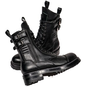 May include: Pair of black leather combat boots with multiple buckles, zippers, and laces. The boots have a thick, lugged sole and a rounded toe. The leather has a textured appearance. The boots are designed for durability and style.