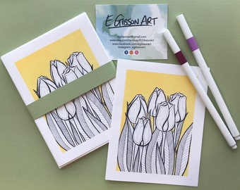 Könnte beinhalten: Ein Satz von fünf Grußkarten mit einer Schwarz-Weiß-Zeichnung von Tulpen auf gelbem Hintergrund. Die Karten sind mit einem grünen Band zusammengebunden.