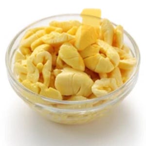 May include: A glass bowl filled with yellow, diced ackee fruit.
