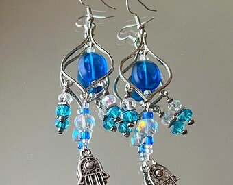chandelier earrings with three tiers and blue faceted iridescent glass beads and a hamsa