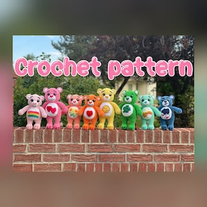 Peut inclure: Un modèle de crochet pour réaliser des oursons arc-en-ciel. Les oursons sont alignés sur un mur de briques et chaque ourson a un cœur et un symbole de couleur différente sur sa poitrine.